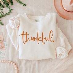 Elevate your casual style with this unisex lightweight Thankful crewneck sweatshirt. Crafted from 100% ring-spun cotton, it offers a soft and smooth feel, perfect for layering or wearing on its own. The relaxed fit ensures comfort, making it an ideal choice for lounging at home, running errands, or enjoying a casual day out with friends. Perfect for all genders, this women's thanksgiving sweatshirt is a great gift for birthdays, holidays, and seasonal celebrations. Its versatility makes it suita Thanksgiving Sweatshirt Ideas, Fall Bonfire, Thankful Sweatshirt, Thanksgiving Sweater, Cart Ideas, Thanksgiving Sweatshirt, Thanksgiving Outfits, Cute Shirt Designs, Holiday Sweatshirt