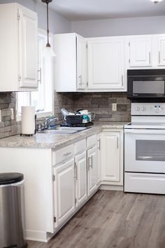 a kitchen with white cabinets and wood flooring, including an electric stove top oven