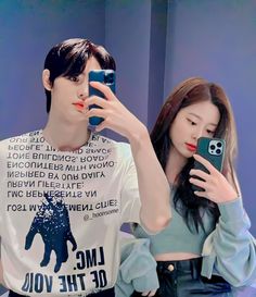 a man and woman taking a selfie in front of a mirror with their cell phones