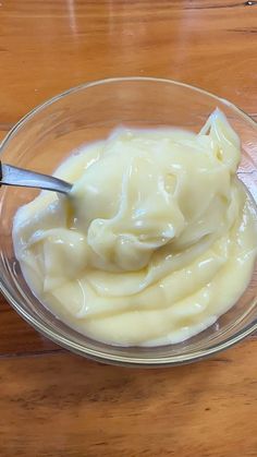 a bowl filled with cream sitting on top of a wooden table