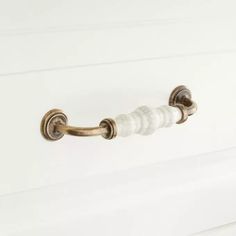 a white door handle with marble accents on it's side and the handles are gold