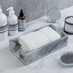 a marble bathroom counter with soap, toothbrush and other items on the counter top