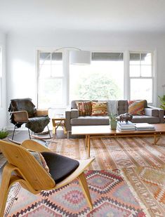 a living room filled with furniture and lots of windows