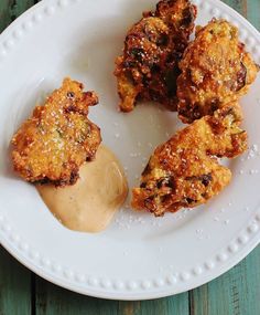 some fried food is on a white plate with gravy and sauce in the middle