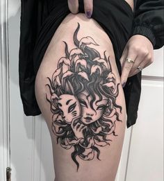 a woman's thigh with a tattoo design on it