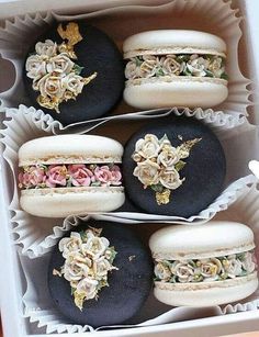 four macaroons decorated with flowers in a box