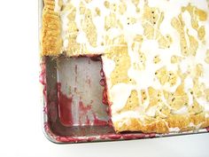 a pie with white icing sitting on top of a red pan filled with food