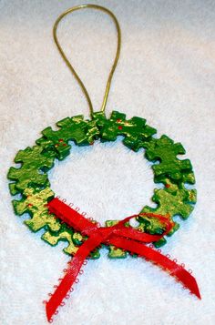 a christmas wreath ornament hanging on a white towel with a red ribbon around it