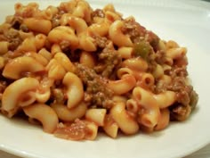 pasta with ground beef and sauce on a white plate, ready to be eaten for lunch