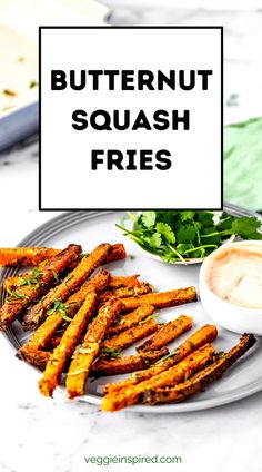 butternut squash fries on a plate with dipping sauce and lettuce in the background