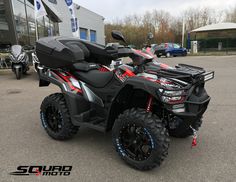 a black and red atv parked in front of a building