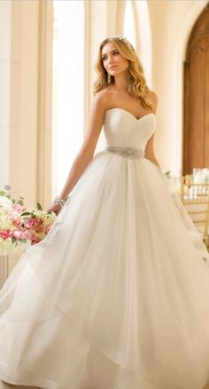 a woman in a white wedding dress is posing for the camera