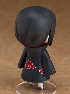 an action figure wearing a black outfit and standing on a clear base with red flowers