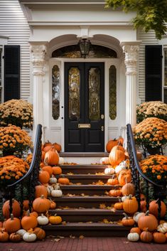 pumpkins and gourds are on the steps in front of a white house