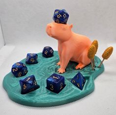 a toy pig with blue and gold numbers on its head sitting in a pond filled with dice