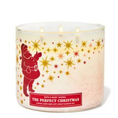 a glass candle with a santa clause design on the front and stars in the back