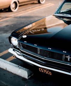 an old mustang sits parked in a parking lot