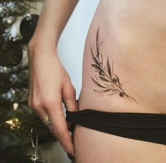 a woman's stomach with a tattoo on her belly and a christmas tree in the background