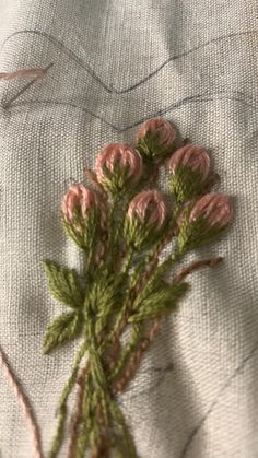 some pink flowers are sitting on a piece of fabric