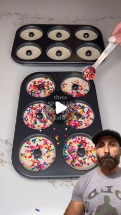 a man is holding a knife over some cupcakes that have sprinkles on them