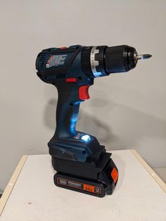 a cordless drill is sitting on top of a small box with a light in it