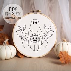 a cross stitch pattern with a ghost holding a jack - o'- lantern in front of some pumpkins