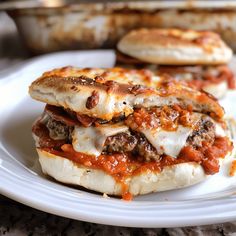 two meatball sandwiches are stacked on a plate