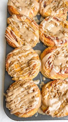 freshly baked cinnamon rolls with icing on a baking sheet, ready to be eaten