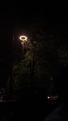 a street light is lit up in the dark at night with no one around it