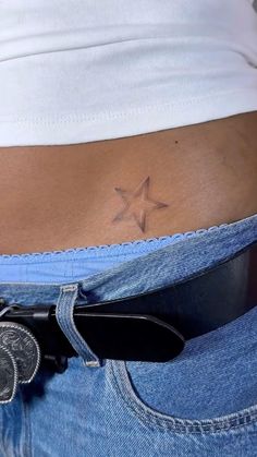 a woman's stomach with a star tattoo on it