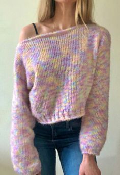 a woman wearing a pink sweater and jeans is posing for the camera with her hand on her hip