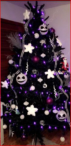 a black christmas tree decorated with purple and white lights, jack - o - lantern ornaments and decorations