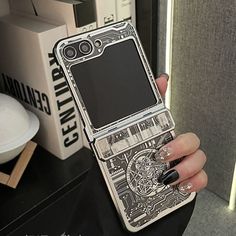 a person holding up a cell phone with designs on the screen and nails in their hands