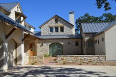 a stone house with two garages and an entry way leading to the front door