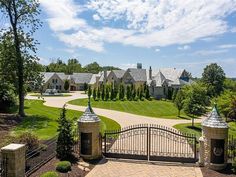 an aerial view of a mansion with driveway and gate