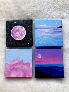 four painted canvases with the moon and mountains in the background on a white surface