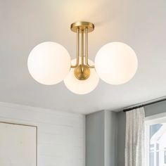 three lights are hanging from the ceiling in a room with white walls and wood flooring