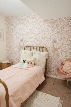 a bedroom with a pink bed and wallpaper