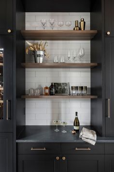 the shelves in this kitchen are filled with wine glasses and champagne bottles, along with other glassware