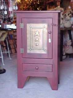 an old fashioned wooden cabinet with metal decoration on the front and sides, sitting in a store