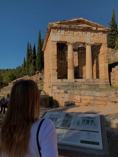 a woman standing in front of an ancient building