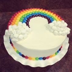 a cake with white frosting and rainbow decorations