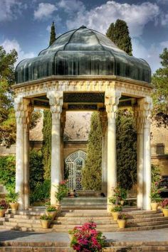 a gazebo with steps leading up to it and potted plants in the foreground