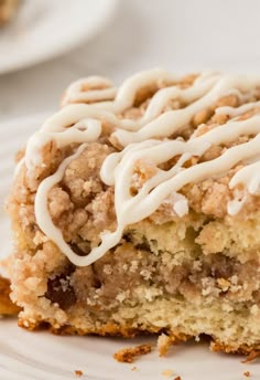 a close up of a piece of cake on a plate with icing and crumbs