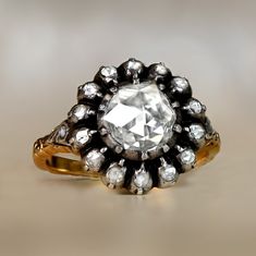 This antique Georgian ring features a 1.00 carat rose cut diamond, J color and VS2 clarity. The center diamond is bezel-set, backed with gold and surrounded by a floral rose cut diamond halo. This ring is silver on 18k yellow gold, and decorated with hand-engravings. Circa 1800. ✦ DIAMOND SPECIFICATIONS: Diamond Cut: Rose Cut Diamond Color: J Color Diamond Clarity: VS2 Diamond Weight: 1.00 Carat ✦ ENGAGEMENT RING SPECIFICATIONS: Material: Silver on 18k Yellow Gold Stones: Diamond Era: Georgian E Georgian Engagement Ring, Engagement Rings Creative, Two Tone Engagement Rings, Vintage Diamond Earrings, Georgian Ring, Estate Diamond Jewelry, Rose Cut Diamond Ring, Georgian Jewelry, Colored Diamond Rings