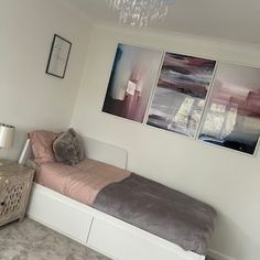 a bedroom with a bed, dresser and two pictures on the wall above it's headboard