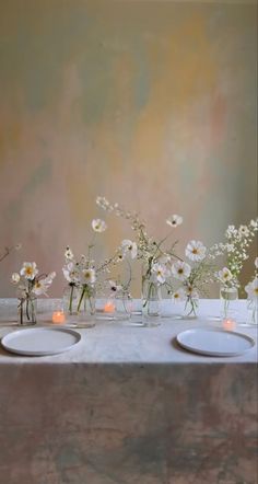 three white plates with flowers in them on a table