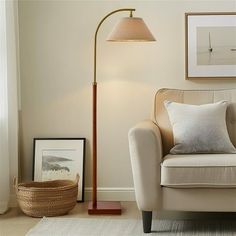 a living room with a chair, lamp and pictures on the wall