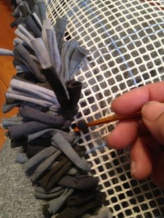 a person is holding an umbrella over some fabric and knitting needles in front of them