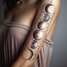 a woman's arm with phases of the moon and stars on her left arm